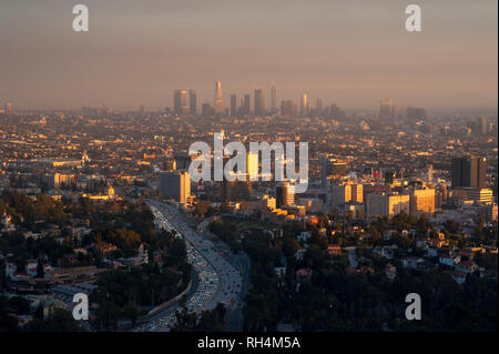 View of Hollywood with downtown Los Angeles in distance through smoggy skies at sunset. Stock Photo