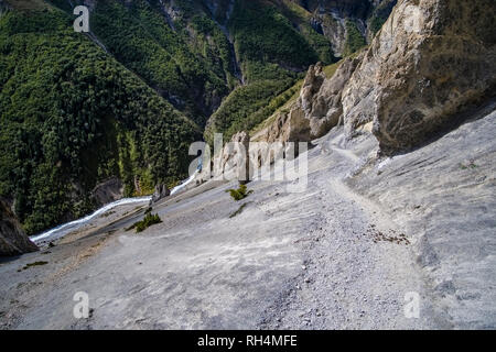 Trail leading to Tilicho Base Camp, crossing very steep and dangerous gravel slopes, view down to the Upper Marsyangdi valley Stock Photo