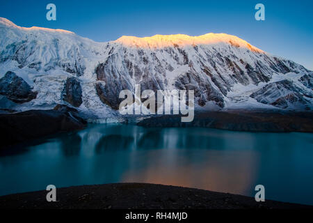 Panoramic view on Tilicho Lake and the snow covered summit of Tilicho Peak at sunrise Stock Photo