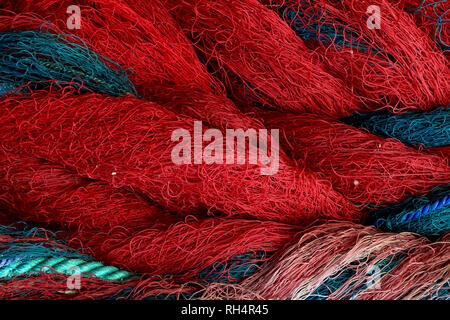 A texture image of a folded large fishing net with red floats and thick  ropes Stock Photo