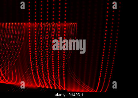 Several red dotted lines with abstract shapes. Light painting photography. Red spots on black background. Stock Photo