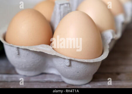 Chicken eggs in the tray close-up. Fresh eggs on wooden table, selective focus Stock Photo