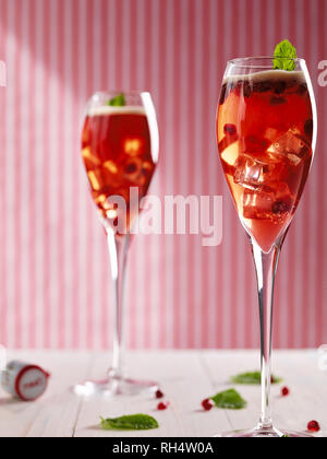 Cocktail made with pomegranate juice, Pimms, and fresh pomegranate seeds, decorated with mint Stock Photo
