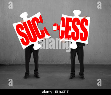 Connecting two puzzles for success concrete background Stock Photo