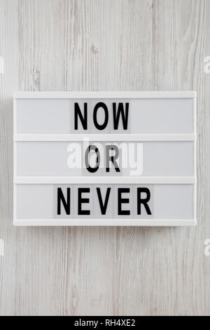 Modern Board With Text 'now Or Never' On A White Wooden Background 