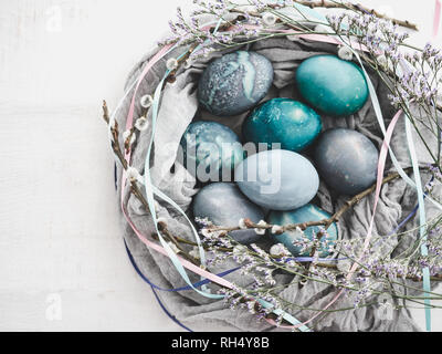 Easter eggs painted in bright colors on a white background. Top view, close-up, isolated. Happy Easter. Preparation for the holiday Stock Photo