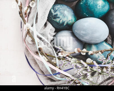 Easter eggs painted in bright colors on a white background. Top view, close-up, isolated. Happy Easter. Preparation for the holiday Stock Photo