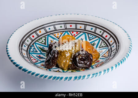delicious moroccan sweet dessert with prunes and dried apricots on a white ceramic plate with multicolor decoration Stock Photo