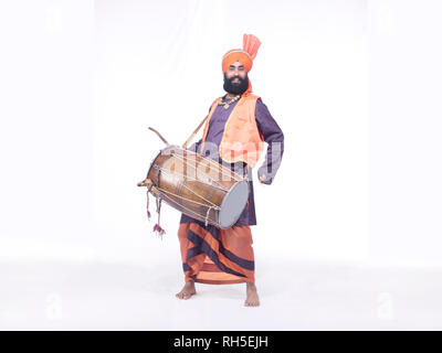 PORTRAIT OF A  BHANGRA DANCER PLAYING THE DRUM, DHOL Stock Photo