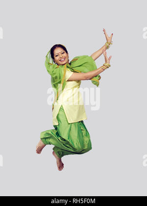 PORTRAIT OF A SARDARNI, SIKH WOMAN JUMPING DANCING THE BHANGRA Stock Photo