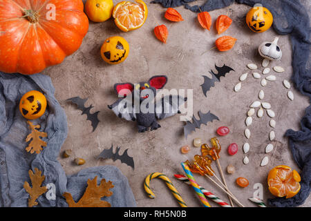 Table with sweets and toys, lollipops and decorated in honor of Halloween. Top view. Stock Photo