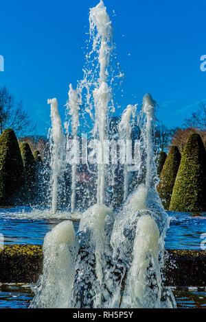 Two fountains in function one opposite the other with trees in the background, wonderful sunny day with a blue sky in the Netherlands Holland Stock Photo