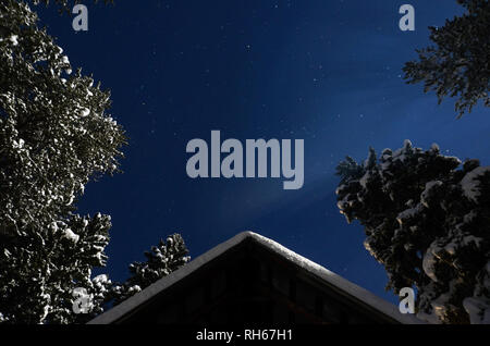 Night skies and cabin by moonlight after snowstorm in winter. Yaak Valley in the Purcell Mountains, northwest Montana. (Photo by Randy Beacham) Stock Photo