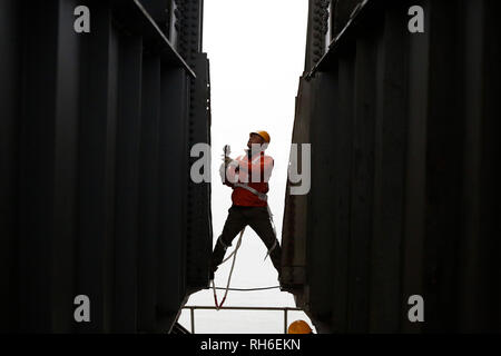 (190201) -- JIUJIANG, Feb. 1, 2019 (Xinhua) -- A bridge worker checks the Jiujiang Yangtze River Bridge, a double-decked road-rail truss bridge and an important section of Beijing-Kowloon (Jingjiu) Railway in Jiujiang, east China's Jiangxi Province, Jan. 31, 2019. Safety inspections have been strengthened to secure transportation during the 2019 Spring Festival travel rush. (Xinhua/Ding Bo) Stock Photo