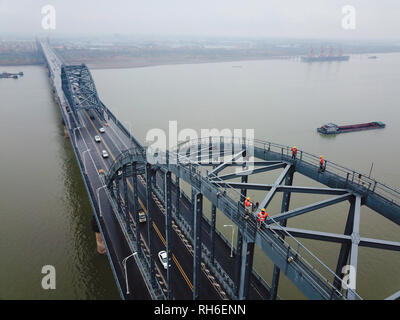 (190201) -- JIUJIANG, Feb. 1, 2019 (Xinhua) -- Aerial photo taken on Jan. 31, 2019 shows bridge workers checking the Jiujiang Yangtze River Bridge, a double-decked road-rail truss bridge and an important section of Beijing-Kowloon (Jingjiu) Railway in Jiujiang, east China's Jiangxi Province. Safety inspections have been strengthened to secure transportation during the 2019 Spring Festival travel rush. (Xinhua/Ding Bo) Stock Photo