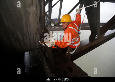 (190201) -- JIUJIANG, Feb. 1, 2019 (Xinhua) -- A bridge worker checks the Jiujiang Yangtze River Bridge, a double-decked road-rail truss bridge and an important section of Beijing-Kowloon (Jingjiu) Railway in Jiujiang, east China's Jiangxi Province, Jan. 31, 2019. Safety inspections have been strengthened to secure transportation during the 2019 Spring Festival travel rush. (Xinhua/Ding Bo) Stock Photo