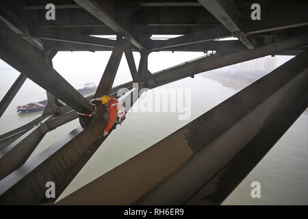 (190201) -- JIUJIANG, Feb. 1, 2019 (Xinhua) -- A bridge worker checks the Jiujiang Yangtze River Bridge, a double-decked road-rail truss bridge and an important section of Beijing-Kowloon (Jingjiu) Railway in Jiujiang, east China's Jiangxi Province, Jan. 31, 2019. Safety inspections have been strengthened to secure transportation during the 2019 Spring Festival travel rush. (Xinhua/Ding Bo) Stock Photo