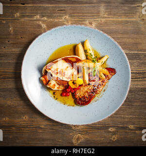 Flat lay of grilled duck liver with pancake and caramelized pear on wooden background Stock Photo