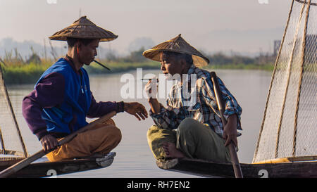 Lake Inle/ Myanmar- January 12,2019: traditional Intha fishermen taking a smoke break with cheroot cigars in the early morning on Lake Inl