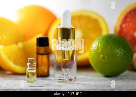 organic essential oil bottles and fruits on wooden table Stock Photo