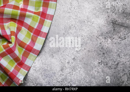 Top view of the checkered tablecloth on the left side of the table with the texture of concrete. Food background Stock Photo