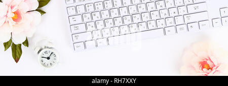 Pink flowers, clock on a white desktop next to a mug of coffee and a keyboard. Top view, flat layout. Copy the space Stock Photo