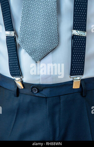 Closeup concept of male look of blue pants with suspenders and shirt with tie Stock Photo