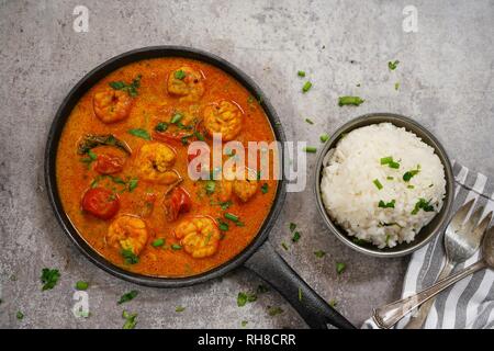 Shrimp in curry coconut sauce with rice in a bowl - Curried prawns,  overhead view Stock Photo