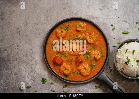 Shrimp in curry coconut sauce with rice in a bowl - Curried prawns,  overhead view Stock Photo