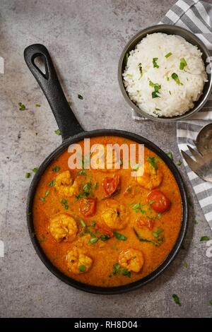 Shrimp in curry coconut sauce with rice in a bowl - Curried prawns,  overhead view Stock Photo