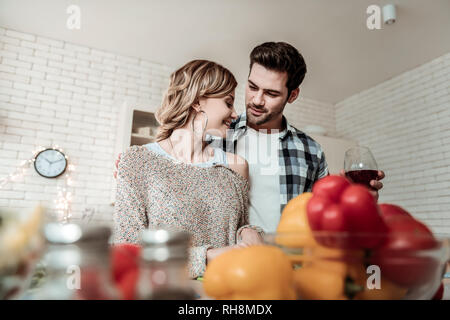 Young beaming pretty woman with big earrings and her husband feeling wonderful Stock Photo