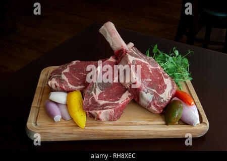 Three Raw Tomahawk Steaks Stock Photo