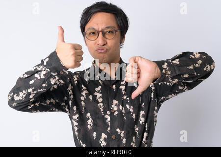 Japanese businessman choosing between thumbs up and thumbs down Stock Photo