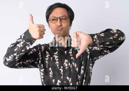Japanese businessman choosing between thumbs up and thumbs down Stock Photo