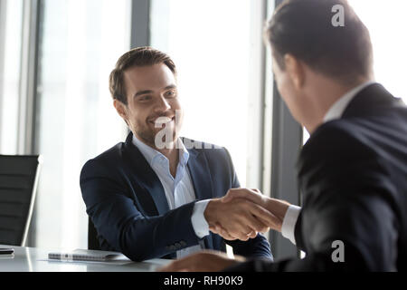 Happy successful businessmen shake hands after group negotiations, gratitude handshake Stock Photo