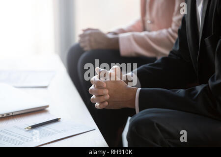 Businessman with clasped hands negotiating about contract at group meeting Stock Photo