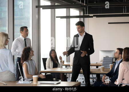 Arabic team leader talking to diverse business people at meeting Stock Photo