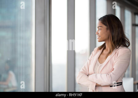 Smiling confident african businesswoman looking at window thinking about future Stock Photo