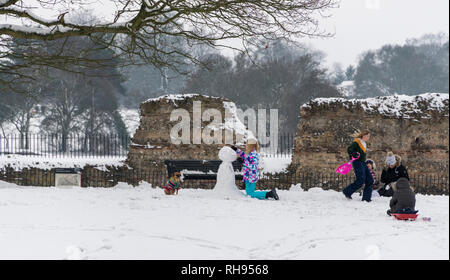 People making a snowman in Verulam Park, St. Albans, Hertfordshire UK Stock Photo