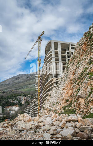 High unfinished buildings and hotels in raw state in Petrovac bay, on the coast in Montenegro Stock Photo