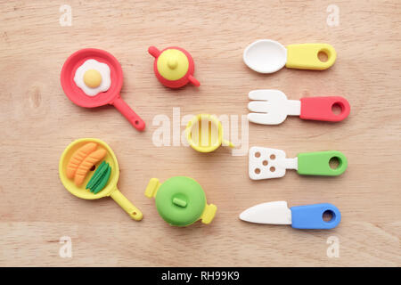 View of miniature toy kitchenware on wood background. Top view. Flat lay. Stock Photo