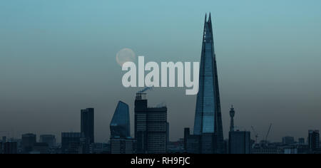 UK Weather: The morning moon sets near the Shard skyscraper building Stock Photo
