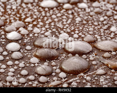 Frozen water droplets on a steel garden table. Stock Photo
