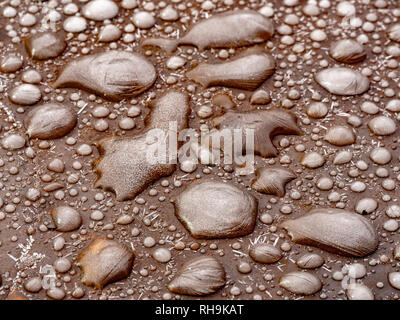 Frozen water droplets on a steel garden table. Stock Photo