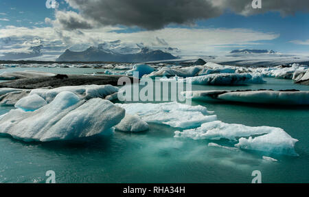 Icebergs in the glacial lake of Jökulsárlón. At the background the Breidamerkurjökull glacier. Iceland Stock Photo