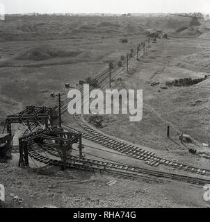 1950s, historical picture showing the landsacpe and rail tracks used by freight wagons to transport the mined lower oxford clay back to the factories of the London Brick Company at the Stewartby brickworks, Bedford, England, UK. Orignally called Wootton Pillinge, the area was renamed Stewartby in 1937, the name of the Stewart family, directors of the LBC. The brickworks was home to the world's biggest kiln. Stock Photo