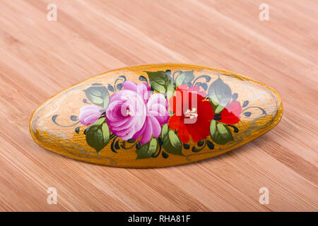 Colorful russian wooden hair clip on wooden background. Stock Photo