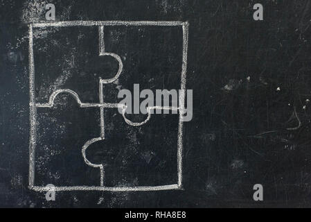 Chalk hand drawing as puzzle shape on black board background Stock Photo