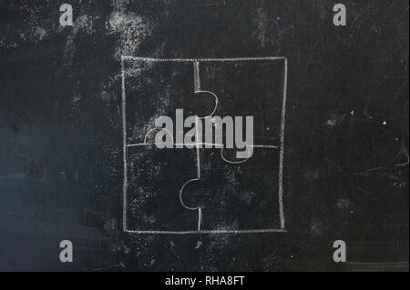 Chalk hand drawing as puzzle shape on black board background Stock Photo