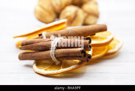 Orange slices with cinnamon in the background cookies on a light wooden table, cooking concept Stock Photo